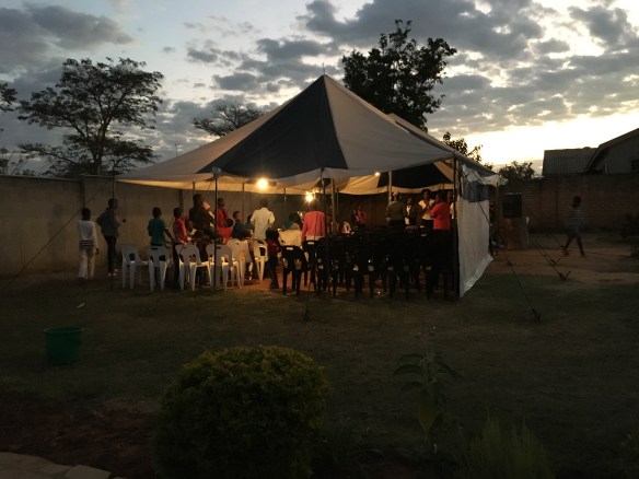 People starting to show up for church. River of Life met in a tent in a member's front yard. 